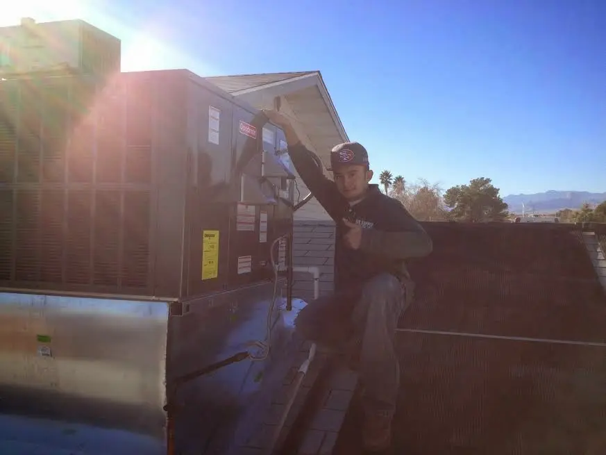 HVAC technician performing Boiler Repair on a rooftop unit in Mesquite